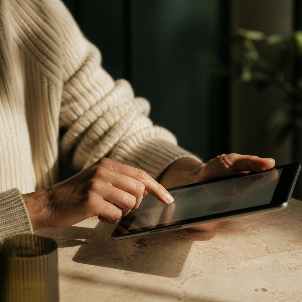 A person using a tablet at home in warm natural light